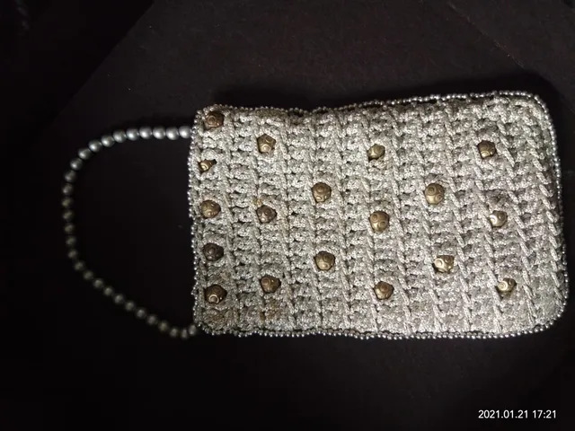 An elegant handmade crochet purse with beads and ivory thread
